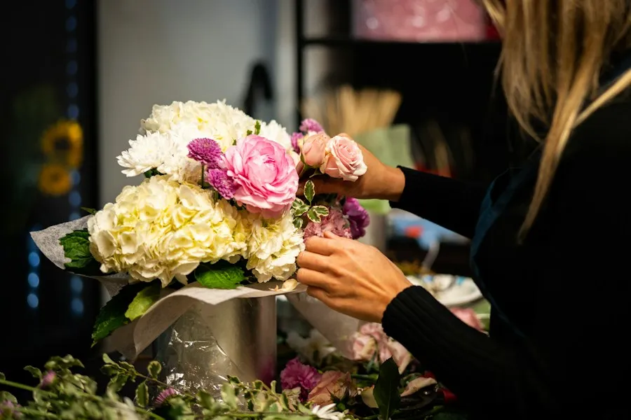 Florist binder en bukett med vita och rosa blommor